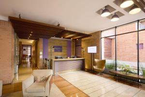 a lobby with a chair and a bar in a building at Mercure Bogota BH Retiro in Bogotá