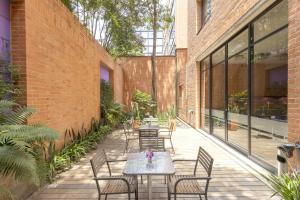a patio with tables and chairs in a brick building at Mercure Bogota BH Retiro in Bogotá