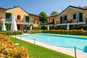 a swimming pool in front of a building with umbrellas at Bellagio Breva in Bellagio