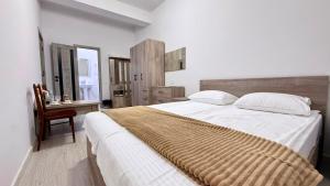 a bedroom with a large bed and a chair at Zvartnoc siti star in Pʼarakʼar