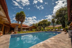a swimming pool in front of a house at Hotel San Agustin Urubamba in Urubamba