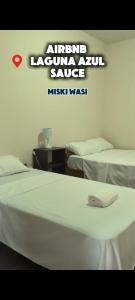 a bedroom with two beds and a sign that reads istgulum acuum sauce at Misky wasy laguna azul in Sauce