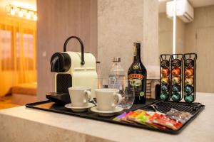 a tray with coffee cups and a bottle of beer at Penthouse Centrum Nitra Jacuzzi&View, free parking in Nitra