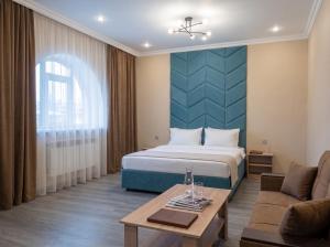 a hotel room with a bed and a couch at Avangard Hotel in Almaty +16 photos