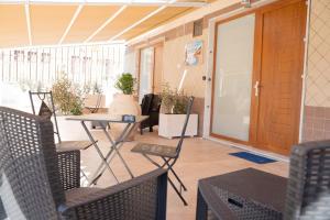 eine Veranda mit Stühlen, einem Tisch und einer Tür in der Unterkunft Affittacamere Iside in Sapri