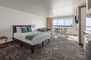 a hotel room with a bed and a balcony at Surfside Resort in Rockaway Beach +58 photos