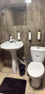 a bathroom with a white toilet and a sink at Guesthouse Mountain House in Khalde