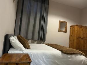 a bedroom with a bed with a table and a window at The pillar in Wexford