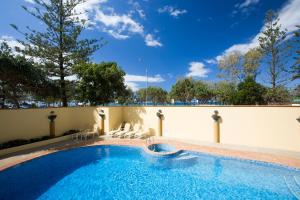 a large swimming pool with chairs and a wall at BreakFree Peninsula in Gold Coast