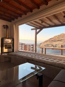 a living room with a couch and a large window at mare Mali Tinos in Mamádhos