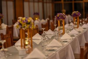 a long table with plates and napkins and flowers on it at Hotel San Agustin Urubamba in Urubamba +29 photos