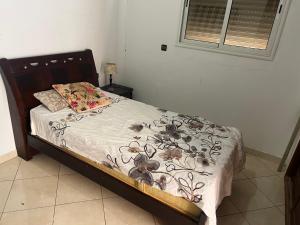 a bedroom with a bed with a floral bedspread at Villa Tamaris, Dar Bouazza in Tamaris