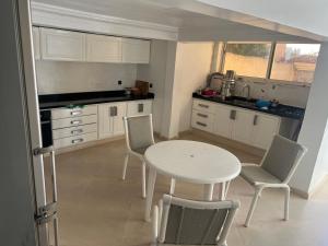 a kitchen with a white table and chairs and a sink at Villa Tamaris, Dar Bouazza in Tamaris