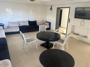a living room with a table and chairs and a couch at Villa Tamaris, Dar Bouazza in Tamaris