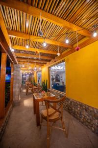 a dining room with yellow walls and wooden ceilings at Hotel San Agustin Urubamba in Urubamba