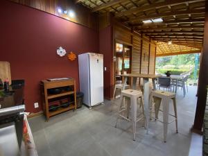 a kitchen with a refrigerator and a table and chairs at Paz e Conforto na Serra Pet Friendly in Teresópolis