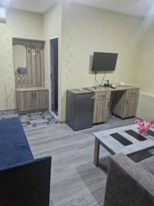 a living room with a television and a desk with a table at Zvartnoc siti star in Pʼarakʼar