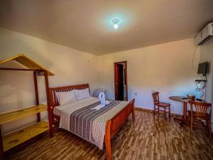 a bedroom with a bed and a table and chairs at Pousada Nativ0s in Baía Formosa +2 photos