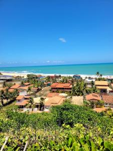 a group of houses with the beach in the background at Pousada Nativ0s in Baía Formosa