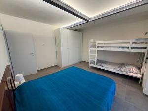 a bedroom with a blue bed and bunk beds at Casa Arianna in Lido di Camaiore