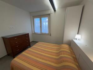 a bedroom with a bed and a dresser and a window at Casa Arianna in Lido di Camaiore