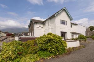a white house with mountains in the background at Stunning 2 bedroom Apartment in Central Keswick in Keswick