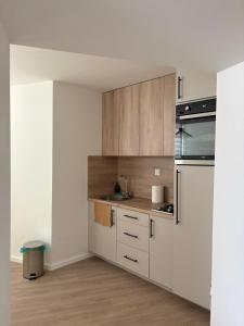a kitchen with white cabinets and a sink at Villa Aba apartments in Sarajevo
