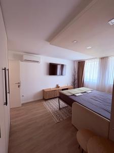 a bedroom with a bed and a tv on the wall at Villa Aba apartments in Sarajevo