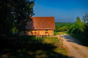 a wooden house with a roof on a dirt road at Smykowe Doły in Wilczyce +26 photos