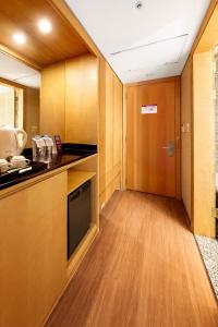 a room with a kitchen with wooden cabinets and a door at Daegu Grand Hotel in Daegu