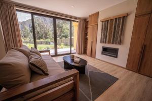 a living room with a couch and a fireplace at Earth Tones Tiny Homes & Suites in Ollantaytambo