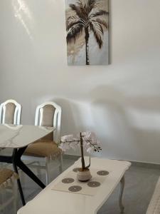 a dining room with a table and a palm tree at Apartments Ana - Airport shuttle option in Podgorica
