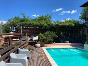 a swimming pool with chairs and a table at Talita Cumi in Villa Santa Cruz del Lago