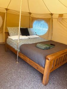 a bed in a tent with a window at Sora Bell Tent in Coxwold