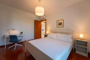 a bedroom with a bed and a desk and a chair at Bellagio Breva in Bellagio +26 photos