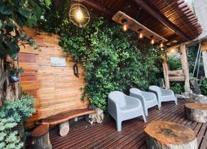a patio with white chairs and a wooden wall at Talita Cumi in Villa Santa Cruz del Lago