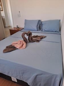 a bed with two blankets on top of it at Brisa do mar região dos lagos in São Pedro da Aldeia
