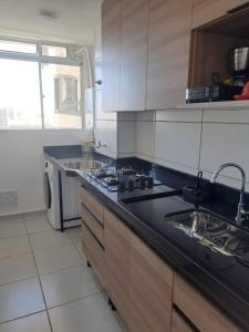 a kitchen with a black counter top and a sink at Brisa do mar região dos lagos in São Pedro da Aldeia