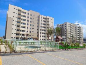a parking lot with two tall buildings in the background at Brisa do mar região dos lagos in São Pedro da Aldeia