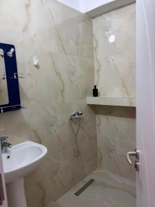 a bathroom with a sink and a toilet and a shower at Lukova rooms in Lukovë