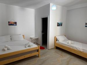 a white room with two beds and a hallway at Lukova rooms in Lukovë +27 photos