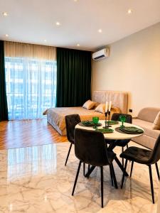a bedroom with a bed and a table and chairs at Sea Breeze Apartments in Baku