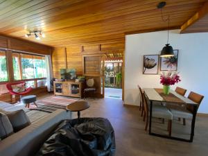 a living room with a couch and a dining table at Paz e Conforto na Serra Pet Friendly in Teresópolis