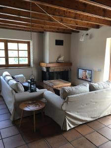 a living room with two white couches and a fireplace at Bellver-Baltarga in Bellver de Cerdanya