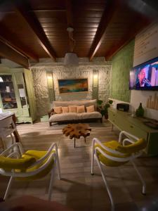 a living room with a couch and a tv at Talita Cumi in Villa Santa Cruz del Lago