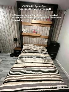 a bedroom with a large bed with a striped comforter at Somewhere Nice & Cozy in Little Clacton
