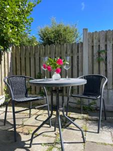 two chairs and a table with two glasses and flowers on it at Ashgrove, Kinsale in Kinsale