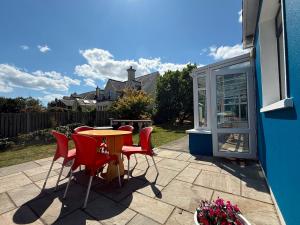 a patio with a table and chairs and a window at Ashgrove, Kinsale in Kinsale