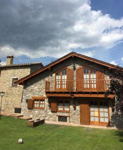 a stone building with a balcony on top of it at Bellver-Baltarga in Bellver de Cerdanya
