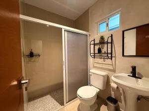 a bathroom with a shower and a toilet and a sink at Casa Villa Leo in Cancún